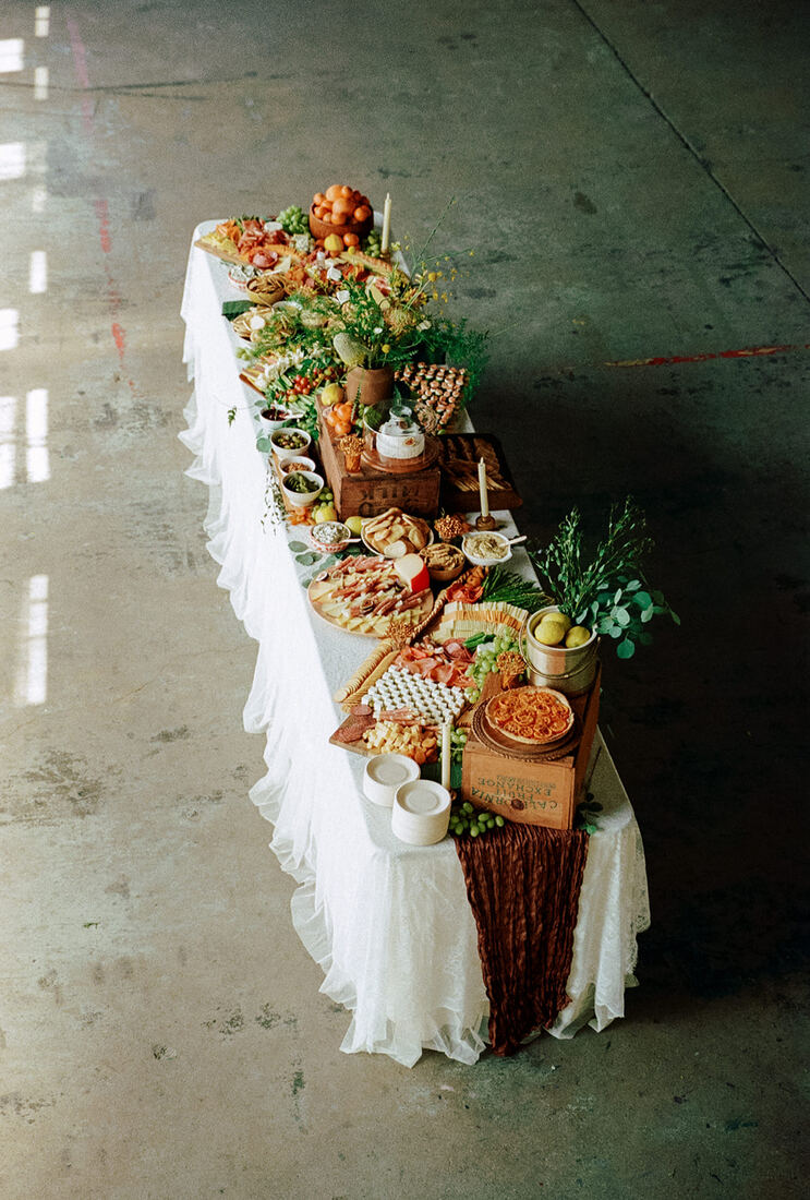 Overhead view of a long wedding grazing table in an industrial venue